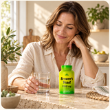 An adult at a kitchen table with a glass of water and Brewer’s Yeast.