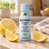 Alfa Magnesium Complex Shot with lemon — bottle close-up on a pale stone counter.