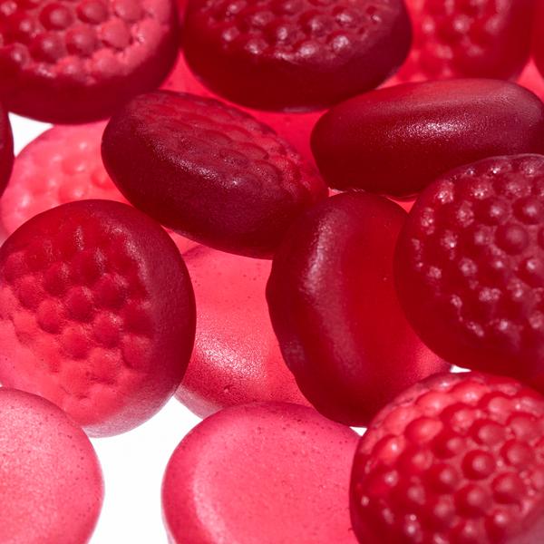 Close-up of assorted red gummy candies, both smooth and textured, from Alfa Vitamins Stores Biotin 5000mcg Adults - 60 Gummies, designed to strengthen nails.